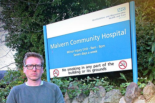 Dan Boatright-Greene standing in front of Malvern Community Hospital